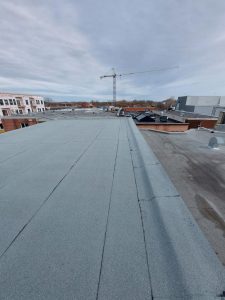 Un bâtiment résidentiel à toit plat après l'application et la pose de la membrane élastomère